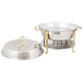 A silver and gold Vollrath classic round chafer with brass trim on a table outdoors.