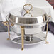 A Vollrath classic round chafing dish with brass trim on a table outdoors.