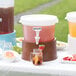 A white Choice beverage dispenser with a brown base on a table with drinks.