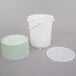 A white plastic bucket with a tap and a green lid.