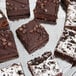 A Vollrath stainless steel round serving tray with a plate of chocolate and white chocolate brownies.