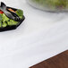 A bowl of vegetables on a white rectangular table covered with an Intedge white poly/cotton tablecloth.