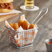 A small metal basket with fried food in it.