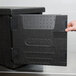 A hand opening a black Cambro GoBox door.