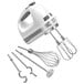 A white KitchenAid 9 speed hand mixer with stainless steel attachments.