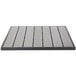 A grey square BFM Seating table top with a black stripe and slats in a patio setting.