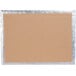 A brown cardboard 1/2 sheet cake board with silver foil on top.