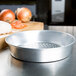 An American Metalcraft silver aluminum pizza pan with holes.
