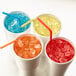 A group of cups with ice and straws next to a Hoshizaki undercounter ice machine.