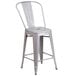 A silver metal outdoor restaurant bar stool with a vertical slat back.