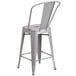 A Flash Furniture silver galvanized steel bar stool with a backrest.