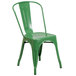 A green Flash Furniture metal chair with a vertical slat back and drain hole seat.