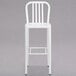 A white metal bar stool with a vertical slat back.