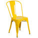 A yellow metal Flash Furniture outdoor restaurant chair with a vertical slat back and drain hole seat.