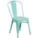 A mint green metal chair with a white background.