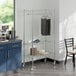 A room with a kitchen and a table and a Regency Chrome Mobile Garment Rack with clothes.