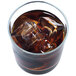 A glass of brown liquid with Manitowoc regular size cube ice in it.