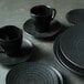 A stack of black Luzerne Urban by Oneida porcelain bowls.