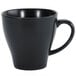 A close-up of a Luzerne Urban by Oneida black porcelain coffee cup with a handle.