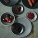 A group of Luzerne Urban Storm porcelain plates with fruits and berries on a table.