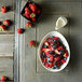 A white Oneida Stage porcelain bowl filled with fruit on a table.