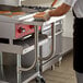 A person cooking pancakes on a Regency stainless steel work surface.