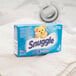 A box of Snuggle fabric softener sheets on a white towel.