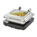 A Vollrath induction chafer with a glass lid and a food pan of vegetables.