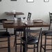 A Lancaster Table & Seating wood butcher block table top with glasses and a napkin on it in a restaurant.