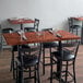 A Lancaster Table & Seating mahogany butcher block table with chairs and napkins.