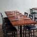 A Lancaster Table & Seating butcher block table with chairs and glasses on it.