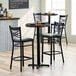 A Lancaster Table & Seating butcher block table with three black bar stools.