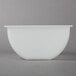 A white Choice condiment holder insert bowl on a gray surface.