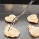 A Mercer Culinary Hell's Handle pot fork sticking out of a piece of meat.