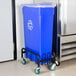 A blue recycle bin on a black Lavex Slim Trash Can Dolly.