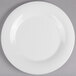 A close up of a GET Diamond White melamine plate with a white rim.