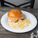 A sandwich on a GET Diamond White wide rim plate with chips on a table.