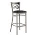 A metal bar stool with a cross back design and a black vinyl padded seat.