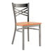 A Lancaster Table & Seating metal cross back chair with a wooden seat.