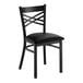 A black metal chair with a cross back design and a black vinyl padded seat.