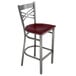 A Lancaster Table & Seating metal cross back bar stool with a mahogany wood seat.