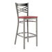 A Lancaster Table & Seating metal cross back bar stool with a mahogany wood seat.