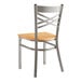 A Lancaster Table & Seating metal cross back chair with a natural wood seat.