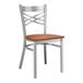 A Lancaster Table & Seating metal cross back chair with a wooden seat and back.