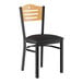 A black metal Lancaster Table & Seating chair with a black vinyl seat and natural wood back.