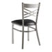 A Lancaster Table & Seating metal cross back chair with a black padded seat.