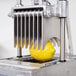 A lemon being sliced by a Nemco Easy Onion Slicer II.