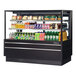 A Turbo Air black refrigerated bakery display case with drinks and snacks inside.