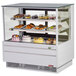 A Turbo Air white flat glass refrigerated bakery display case full of various pastries.