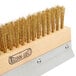 A close up of a Chef Master pizza oven brush head with gold bristles.